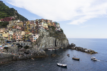 View from the sea to the harbor and the little town of Manarola, Cinque Terre, Italy