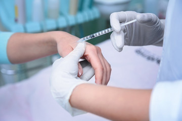 Dermatologist making injection in hand of patient