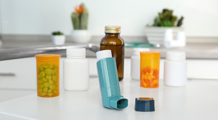 Asthma inhaler and medications on table