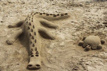 Crocodile and turtle built of sand on the beach of Praia da Luz, Portugal