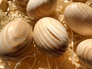Wooden eggs in a box with sawdust.