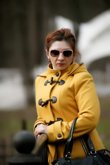 Woman wearing sunglasses and a yellow coat