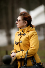 Woman wearing sunglasses and a yellow coat