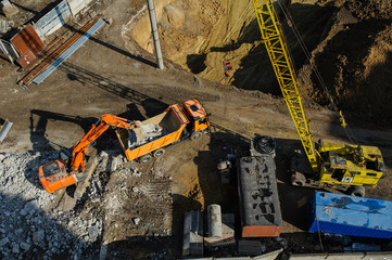 excavator moving earth and unloading into a dumper truck