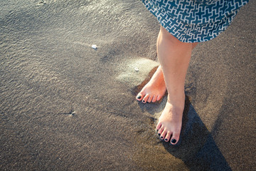 Beautiful bare female feet on the beach