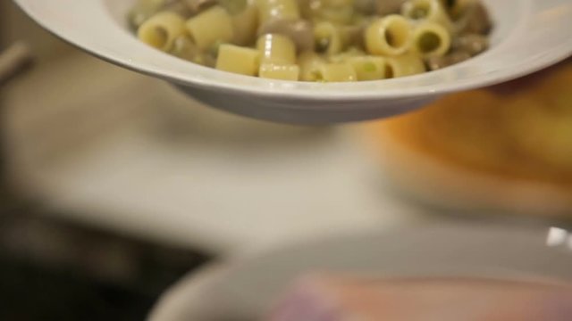 donna impiatta pasta e fave in un piatto bianco in una cucina di casa italiana