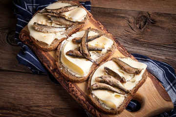 Sandwich with sprats and cheese.