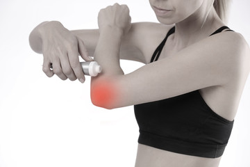 Woman suffering from elbow pain applying pain relief cream