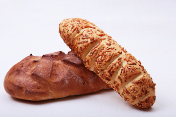 Assorted fresh breads, slice and knife isolated on old wood table.