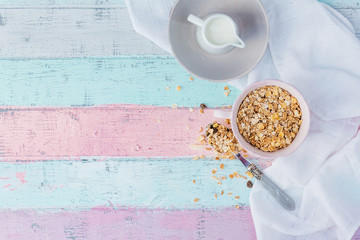 Muesli in bowl over wooden background. Healthy food with copy space