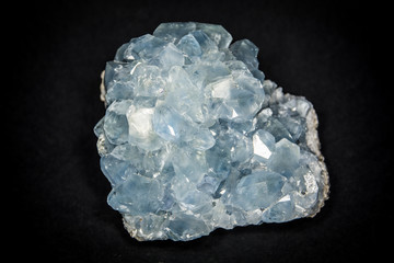 A celestite or celestine stone placed on black background, isolated. Horizontal studio shot.