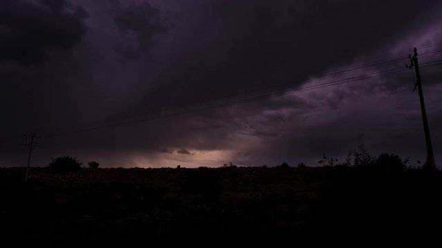 A static timelapse of a typical Karoo scene with a dramatic thunderstorm and dark clouds moving through, framed by telephone poles available on request.
