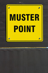 Muster assembly point sign on a wooden wall