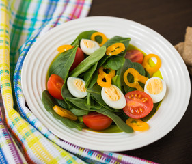 Healthy food. Fresh salad of spinach with cherry tomatoes, bell pepper and quail eggs