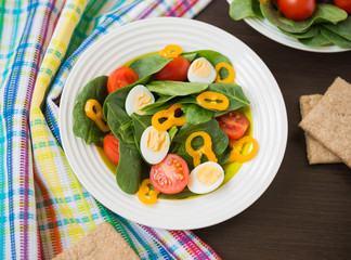 Healthy food. Fresh salad of spinach with cherry tomatoes, bell pepper and quail eggs