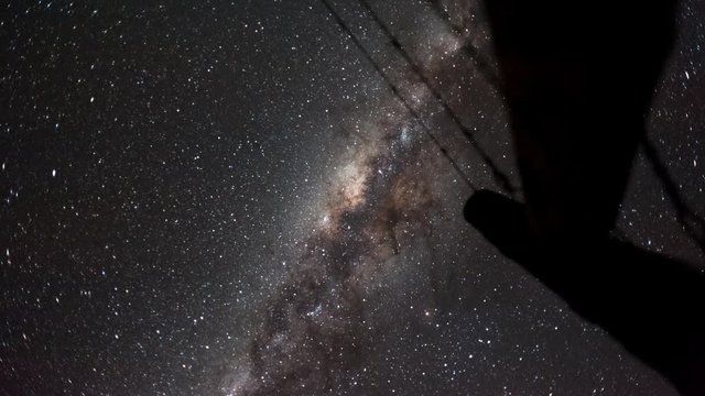 Linear, pan and tilt timelapse shot from a low angle shooting up towards an old farm gate silhouetted against the African night sky with the Milky Way moving through available on request.
