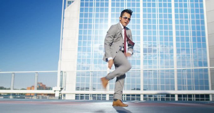  Young urban street dancer in smart suit showing off some moves in city