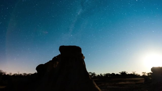 Linear, push-in night timelapse of abstract landscape with silhouette eroded rocks while the moon is setting and the Milky Way moves into the frame available on request.