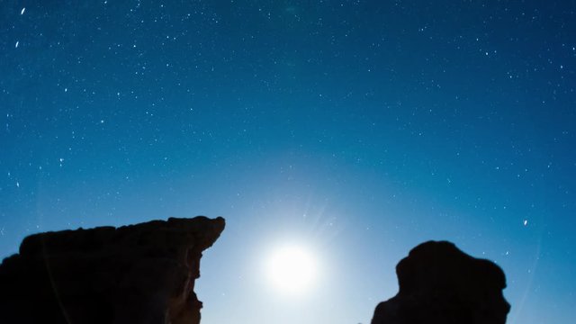 Linear pull-back abstract timelapse at night of the moon setting with silhouette eroded rock formations in the foreground with the Milky Way moving into the frame and setting available on request.