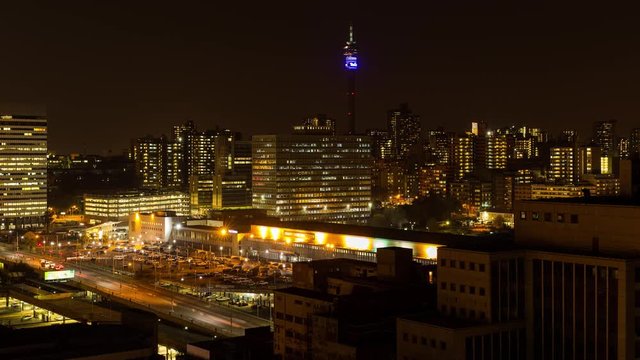 Static night timelapse of the Johannesburg Park station (Gautrain) showing the hustle and bustle of people at the train station parking area during peak traffic time after work, South Africa