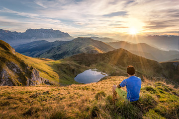 Man sitting on a mountain summit enjoying the view