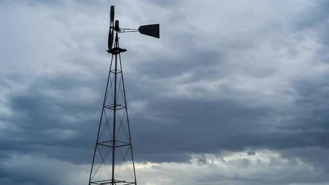 Static timelapse of a franticly blowing windmill silhouetted against a dramatic and stormy sky with thunder and lightning while the clouds are constantly changing and blows from right to left available on request.