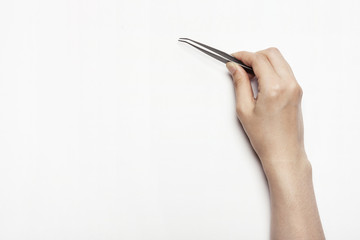 woman(female) hand hold a pincers isolated white.