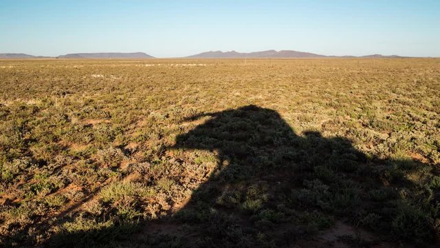 A static timelaspe in the early morning sun of a safari tent on top of a 4x4 vehicle in a typical Karoo landscape