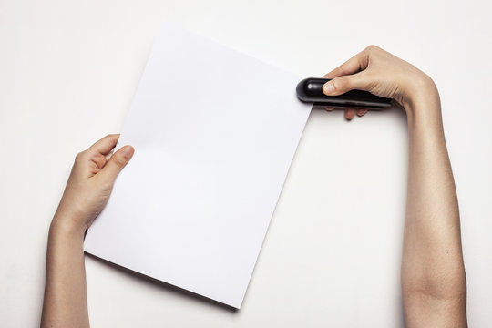 woman(female) hand hold a stapler with paper isolated white.