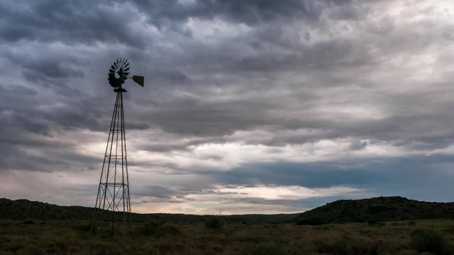 Static timelapse of a franticly blowing windmill silhouetted against a dramatic and stormy sky with thunder and lightning in a typical Karoo landscape available on request.