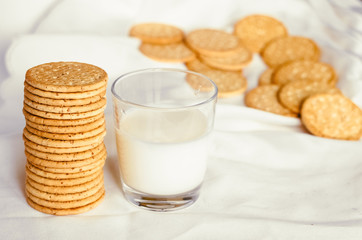 A glass of milk with a biscuit biscuit