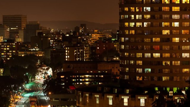 Close-up night timelapse panning across Ponte Towers and the city centre of Johannesburg during peak traffic with streets and buildings, South Africa