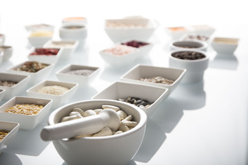 leguminous vegetables and spices in bowls, isolated on a white background