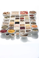 leguminous vegetables and spices in bowls, isolated on a white background