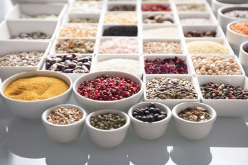 leguminous vegetables and spices in bowls, isolated on a white background