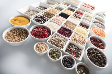 leguminous vegetables and spices in bowls, isolated on a white background