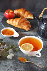 Lemon tea, jam and two fresh croissants