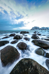 Ancient stones on the shores of cold Norwegian Sea at evening time. Lofoten islands. Beautiful Norway landscape.