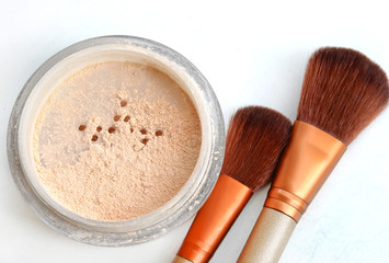 Close up of face powder and cosmetic brush