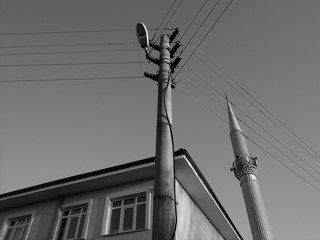 Straßenecke mit Minarett und Strommast im Licht der untergehenden Sonne in Maksudiye in der...