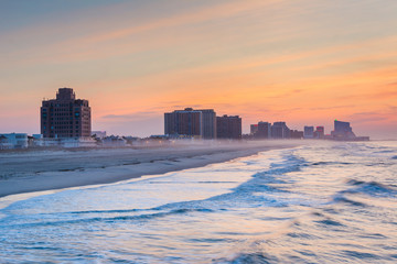 Waves in the Atlantic Ocean and buildings at sunrise, in Ventnor City, New Jersey.