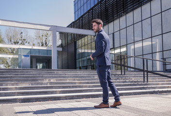 one young man, posing standing, suit outdoors