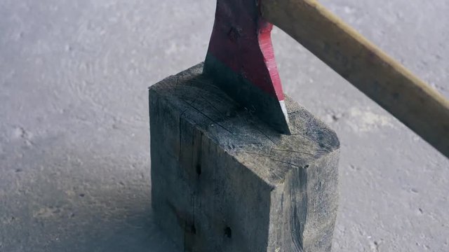 Ax cutting a rope on a wooden block