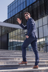 one young man, suit hand waving, back rear view