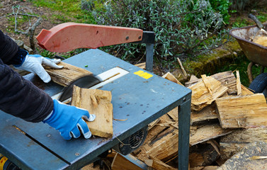 man making firewood with buzz saw