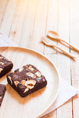 Chocolate brownie cake served on wooden plate.