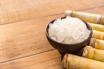 Rock sugar and sugar cane on wooden table background with sunlight in morning time