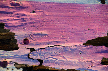 Decayed wooden structure painted in pink and yellow nuances.