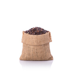 Thai black sticky rice in small sack. Studio shot isolated on white background