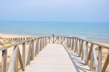 Bridge of wood and concrete leading to the sea and the park
